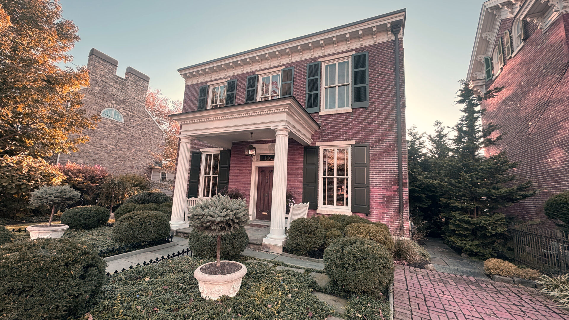 An old brick 19th century house with a columned portico.